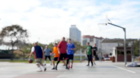 Cinematic out of focus slow motion shot of men playing basketball on open air Vídeo Stock 132648292