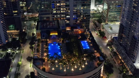 Cinematic overhead view on rooftop bar and pool with palm trees fireplaces Miami Stock Footage 148360212