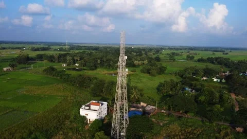 Cinematic Overlook of Mobile Network Mast in Vast Green Farmland. Stockbeeldmateriaal 331031991