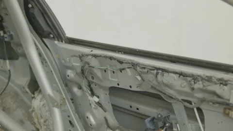 Cinematic pan along stripped bare metal car door interior frame Stock Footage 345688389