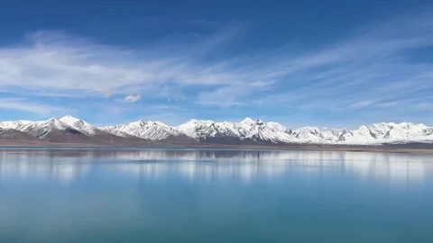 Cinematic pan of snow mountain reflections in Tibet lake Video stock 333553575