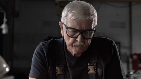 Cinematic portrait of an elderly locksmith working at a lathe in a factory Stock Footage 212384563