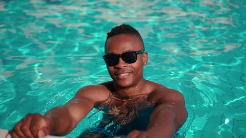 Cinematic Portrait Of Happy Hipster Black Man On Summer Holiday In Pool Stock Footage
