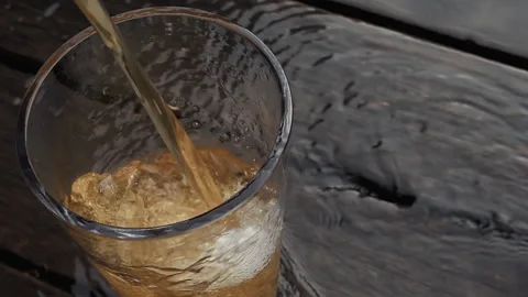 Cinematic Pour of Cold Craft Beer into Glass on Dark Rustic Wood Stock Footage 335787917