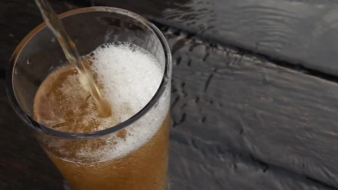 Cinematic Pour of Cold Craft Beer into Glass on Dark Rustic Wood Stock-Footage 335787924