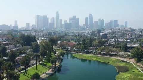 Cinematic pullback view of Echo Park lake with car traffic, downtown LA skyline Stock Footage 273835361