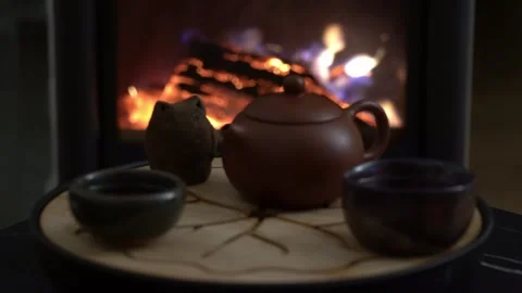 Cinematic refocus from burning fireplace to traditional tea ceremony set 库存影片 329558491