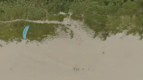 Cinematic rising drone shot tracking a paraglider moving left to right over Vídeo Stock 333986928