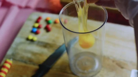Cinematic serving study of cracking eggs into a tall mixing cup Stock Footage 342154014