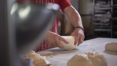 Cinematic shot of baker rolling fresh dough in bakery. Stock-Footage 107775609