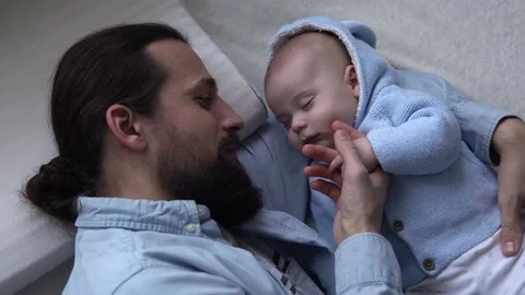 Cinematic Shot Bearded Long-haired Young Neo Father Strokes Face Newborn Baby In Stock Footage 168445568