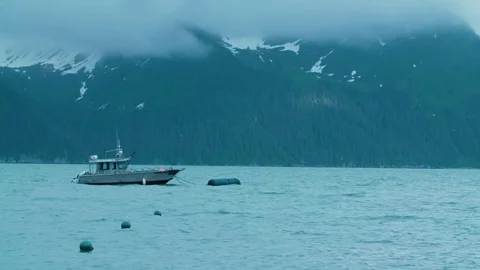 Cinematic Shot of Boat Bobbing in Dramatic Seas with Mystical Mountains and Fog Stock Footage 83132969
