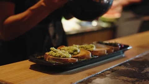 Cinematic Shot of a Chef Spreading Mashed Avocado onto Toasted Sourdough Bread Video stock 334665442