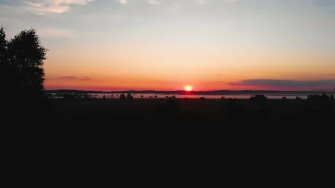 Cinematic shot of fields at a calm orange sunset. Sunbeams. Fog Stock Footage 199017789