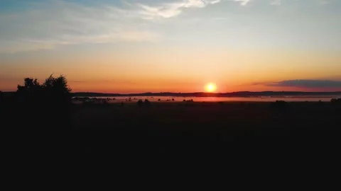 Cinematic shot of fields at a calm orange sunset. Sunbeams. Fog Stock Footage 199017888