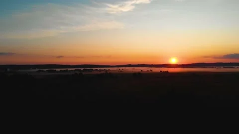 Cinematic shot of fields at a calm orange sunset. Sunbeams. Fog Stock Footage 199017992