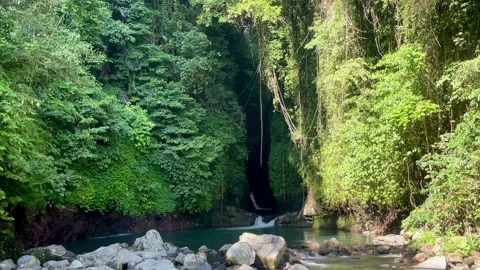 Cinematic shot of a hidden cave turquoise pool in Bali jungle Stock Footage 336904248