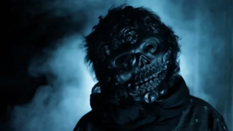 Cinematic shot of a man wearing a scary mask in dramatic light, with some fog. 動画素材 205026853