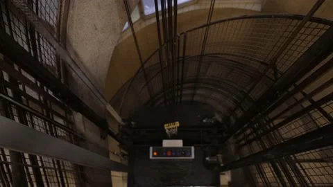 Cinematic shot of an old vintage elevator shaft ascending and rising Stock Footage 156224435