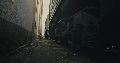 Cinematic shot: The passage between the wall of the building and the standing Stockbeeldmateriaal 156461538