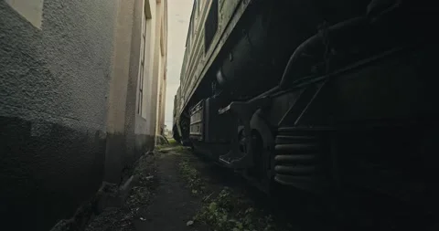 Cinematic shot: The passage between the wall of the building and the standing Stockbeeldmateriaal 165081863