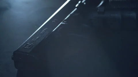 Cinematic shot of a rotating pistol on a table with smoke on the dark background Stock Footage 64377620