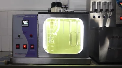 Cinematic shot of viscosity bath testing, Pure gold liquid shining during the Stock Footage 301594759