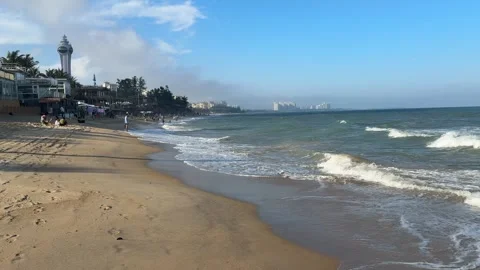 Cinematic Side View of Qionghai Beach with Tourists and Skyline 4K 库存影片 331971419
