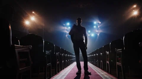 Cinematic Silhouette of Man Taking Off Jacket on Stage. Ready to Action Concept Stockbeeldmateriaal 336338906