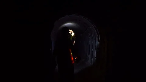 Cinematic Silhouette of Worker Walking Towards Light and Colleagues at Tunnel Vídeos de archivo 334939488