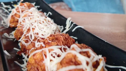 Cinematic Slow Motion Close-Up of Fried Chicken Wings with Shredded Cheese 動画素材 344534676