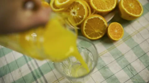 Cinematic slow motion high shot of person pouring juice into glass cup near Stock Footage 341244812