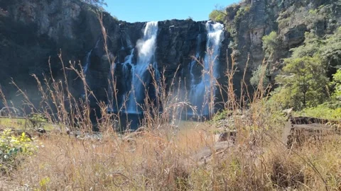 Cinematic Slow Motion Slide Past Dry Grass With Waterfall Background Stock Footage 340470218