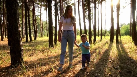 Cinematic slow motion view on young sister picking up hugging cute little Stock Footage 104371420