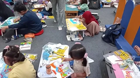 Cinematic slow pan shot of a crowded kids coloring contest at a mall atrium Stock Footage 337531229
