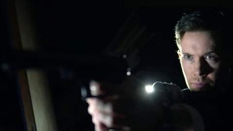 Cinematic Special Agent Spy Aims Gun At Night, 4K Stock Footage 99663717