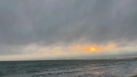 Cinematic Sunset Glow over Ocean Waves and City Skyline 4K Stock Footage 331897193