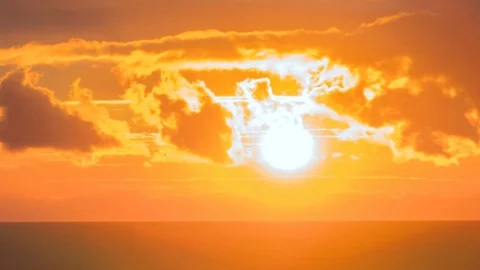 Cinematic sunset. Large orange sun through the clouds over the ocean. Video stock 83968937