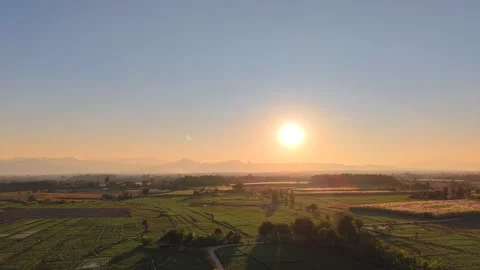 Cinematic Sunset Over Lush Fields and Faraway Mountains Video stock 326176321