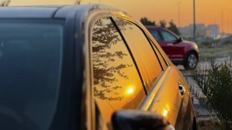 Cinematic sunset reflection on black car window Stock Footage 334408957
