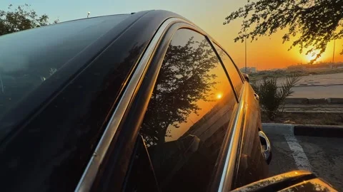 Cinematic sunset reflection on black car window Stock Footage 334409739