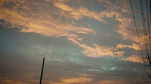Cinematic sunset sky with golden clouds and power line silhouette Stock Footage 346341790