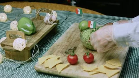Cinematic tabletop composition of tortilla chips arranged around guacamole Stock Photos