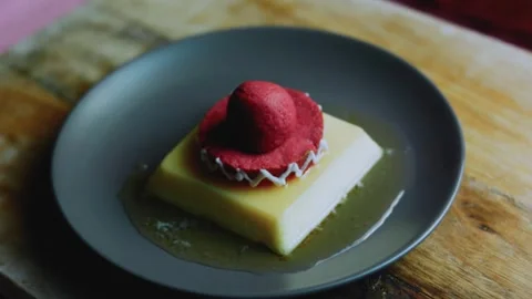 Cinematic tabletop study of square caramel flan topped with a festive hat Stock Footage 342154149