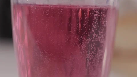 Cinematic tilt up macro of red bubbles and carbonation Stock Footage 332724617