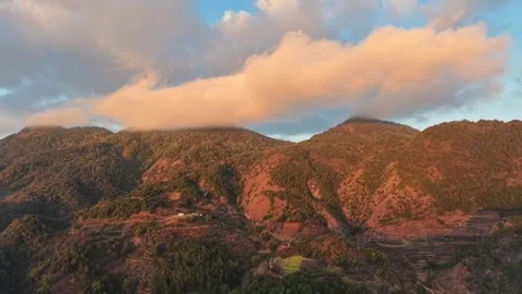 Cinematic time-lapse of golden clouds moving over mountain ridges at sunset. Stock Footage 328691337