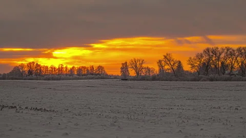 Cinematic timelapse of dramatic sunrise with orange sunlight struggling to Stock Footage 219933883