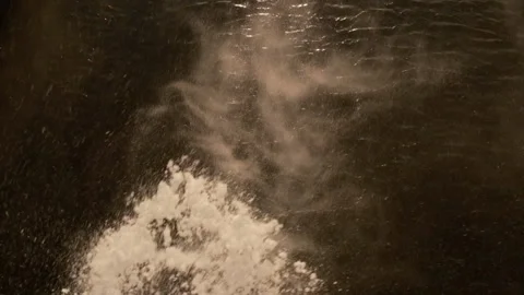 Cinematic top-down shot of a river flowing beneath falling snow Video stock 328536684