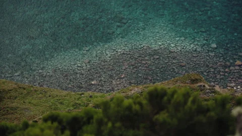Cinematic Top-Down View of Crystal Clear Turquoise Water and Rocky Seabed along Видео 335010708