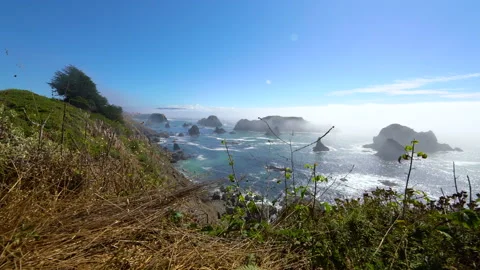 Cinematic tracking shot of sea stack in foggy coastline in Northern California Video stock 136717889